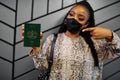 African woman wearing black face mask show Lesotho passport in hand. Coronavirus in Africa country, border closure and quarantine