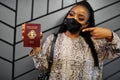 African woman wearing black face mask show Seychelles passport in hand. Coronavirus in Africa country, border closure and