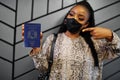 African woman wearing black face mask show Somalia passport in hand. Coronavirus in Africa country, border closure and quarantine