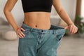 African Woman Wearing Old Large Jeans After Slimming Indoor, Cropped Royalty Free Stock Photo