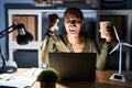 African woman working using computer laptop at night angry and mad raising fist frustrated and furious while shouting with anger Royalty Free Stock Photo