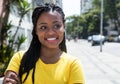 African woman in a yellow shirt in city looking sideways Royalty Free Stock Photo