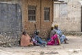 African women and children seat on the street near home of Zanzibar island, Tanzania, East Africa