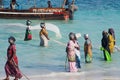 African women from a fishing village to catch small fish nets in the ocean
