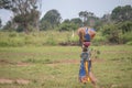 African women walk in nature, carrying large cargo on her head