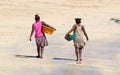 African women walking over the beach with laundry Royalty Free Stock Photo