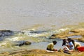 African women washing clothes on a river. Washed clothes are lie Royalty Free Stock Photo