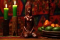 african wooden statuette next to kwanzaa candles