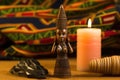 african wooden statuette next to kwanzaa candles