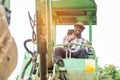 African worker driving heavy construction equipment backhoe with smile and happy