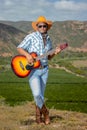 An African Xhosa cowboy in the countryside of South Africa playing his guitar. Royalty Free Stock Photo