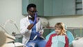 African young dentist finishing check the teeth of little girl.