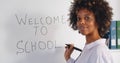 African young female teacher writing welcome to school on white board in classroom Royalty Free Stock Photo