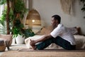 African young man sitting in paschimottanasana or Intense Dorsal Stretch pose, seated forward bend posture