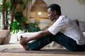 African young man sitting in paschimottanasana or Intense Dorsal Stretch pose, seated forward bend posture