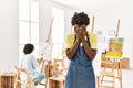 African young man standing at art studio with sad expression covering face with hands while crying Royalty Free Stock Photo