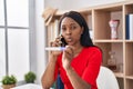 African young woman holding pregnancy test result speaking on the phone looking at the camera blowing a kiss being lovely and sexy