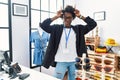 African young woman working as manager at retail boutique doing funny gesture with finger over head as bull horns