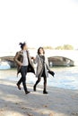 Afro american boy and caucasian girl running near Seine bridge, Paris. Royalty Free Stock Photo