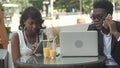 Afro-american business man and woman working together in modern cafe, having phone calls, using laptop and digital Royalty Free Stock Photo