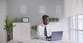 Afro-american businessman finishing work on laptop, putting on jacket and going home Royalty Free Stock Photo