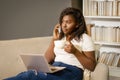 Afro American Businesswoman Has a Coffee Break in the Meddle of the Working Day. Woman Sitting on the Couch Talking on