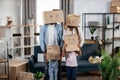 Parents and kids with boxes on heads standing at new house Royalty Free Stock Photo