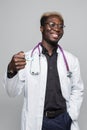Afro american Doctor holding pills in hands isolated on gray background Royalty Free Stock Photo