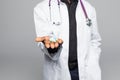 Afro american Doctor holding pills in hands isolated on gray background Royalty Free Stock Photo