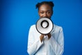 Afro american female doctor in white medical gown scream in megaphone in studio