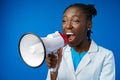 Afro american female doctor in white medical gown scream in megaphone in studio