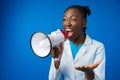 Afro american female doctor in white medical gown scream in megaphone in studio