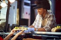 Afro-american female employee in fast food service giving sandwiches to a customer with a smile