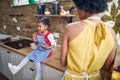 Sweet Moments in the Kitchen: Afro-American Girl Enjoying a Cookie while Her Mother Looks on Lovingly Royalty Free Stock Photo