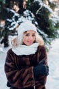 Afro american girl wearing in fur coat and knitted white hat in park in winter sunny day Royalty Free Stock Photo
