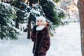 Afro american girl wearing in fur coat and knitted white hat in park in winter sunny day Royalty Free Stock Photo