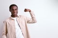 afro american guy showing arm muscles, powerful strong man isolated on white Royalty Free Stock Photo