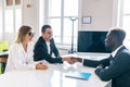 Afro american investment advisor shaking hands with smiling man while consulting with young couple about financial savings Royalty Free Stock Photo