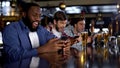 Afro-american man celebrating successful bet on match, online bookmaker on phone Royalty Free Stock Photo