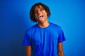 Afro american man with dreadlocks wearing t-shirt standing over isolated blue background sticking tongue out happy with funny Royalty Free Stock Photo