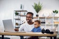 Afro american man using and taking care of son Royalty Free Stock Photo