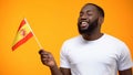 Afro-American man holding Spain flag, political support, international relations