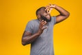 Afro american man isolated against yellow background smelling something stinky and disgusting, intolerable smell, holding breath