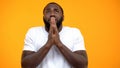 Afro-American man praying and looking up isolated on yellow background, belief Royalty Free Stock Photo