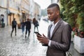 Afro american man in suit using smartphone on street Royalty Free Stock Photo