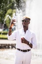 Afro american man take selfie on phone near fountain or make vidio streem live translation on summer streets Royalty Free Stock Photo