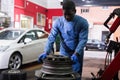 Afro american man working with tire fitting machine Royalty Free Stock Photo