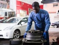 Afro american man working with tire fitting machine Royalty Free Stock Photo