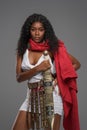 Afro-American model in Greek-style tunic with red cape and ornate belt