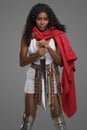 Afro-American model in Greek-style tunic with red cape and ornate belt